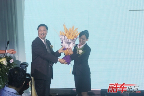 河南省商务厅副厅长戴松军向郑州富达雷克萨斯赠送象征“大卖”的大麦花束